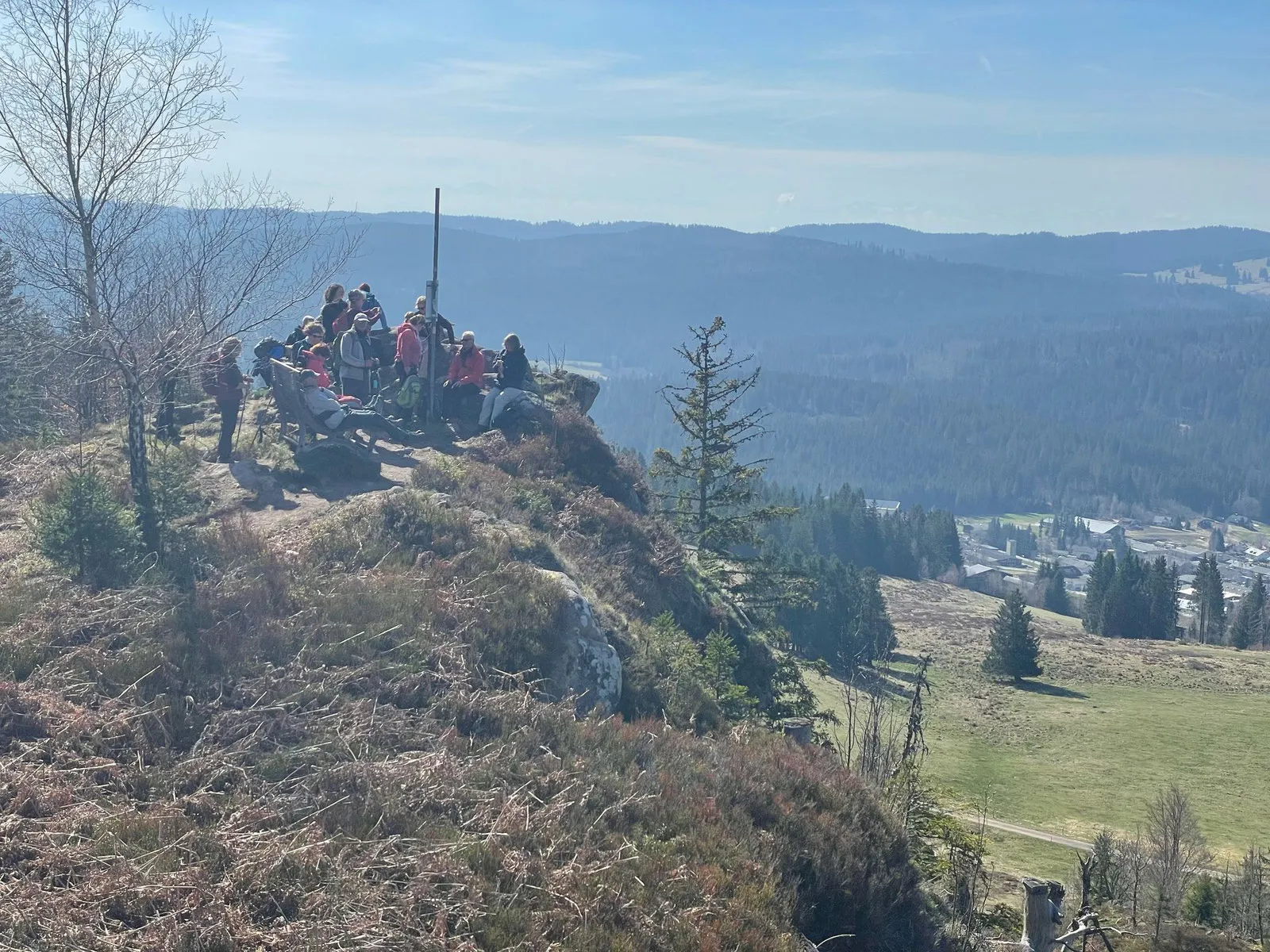 Die Gruppe rastet auf einem Felsen hoch über dem Tal, im Hintergrund der Hochschwarzwald